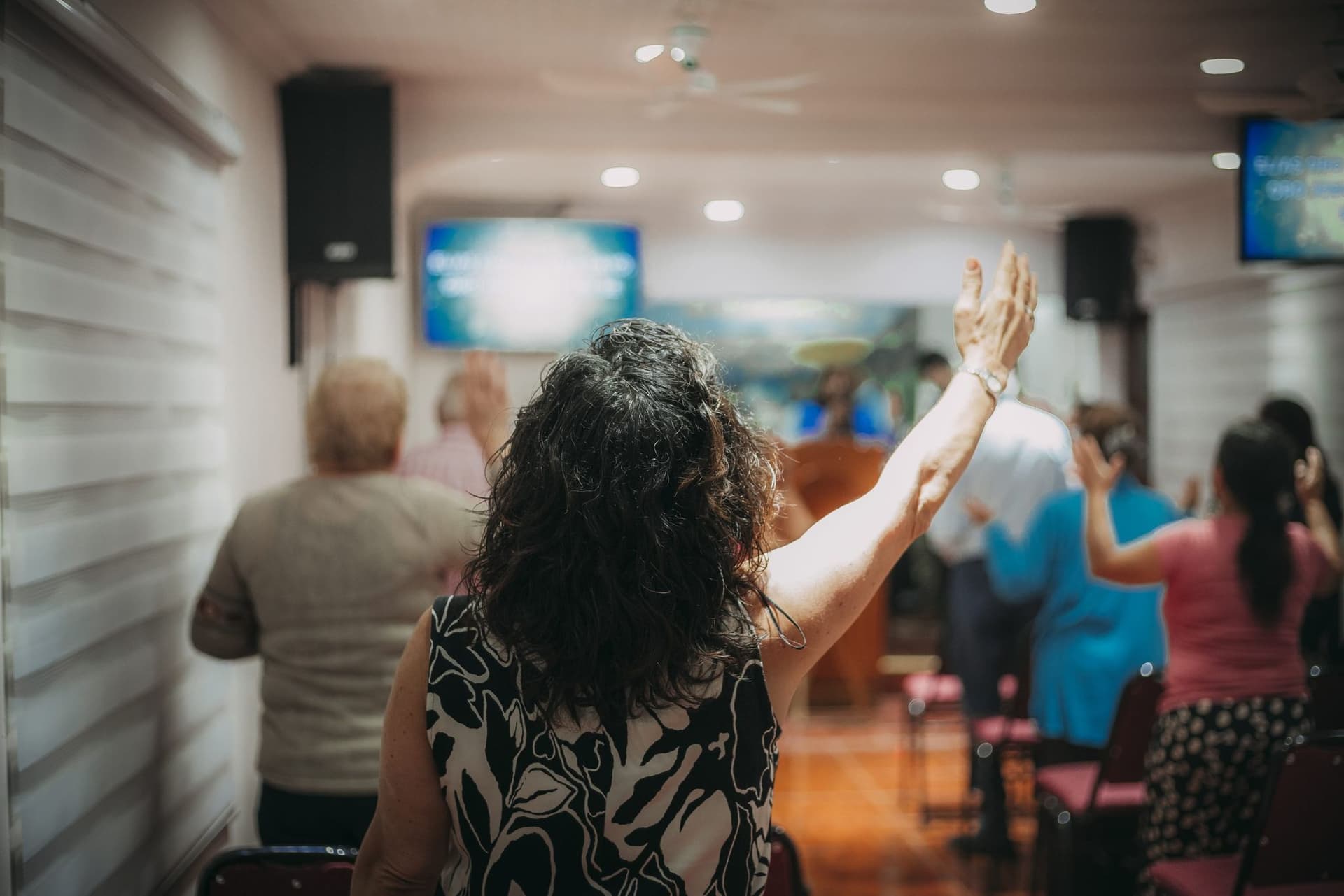 Hermana en adoración con la mano levantada durante el culto